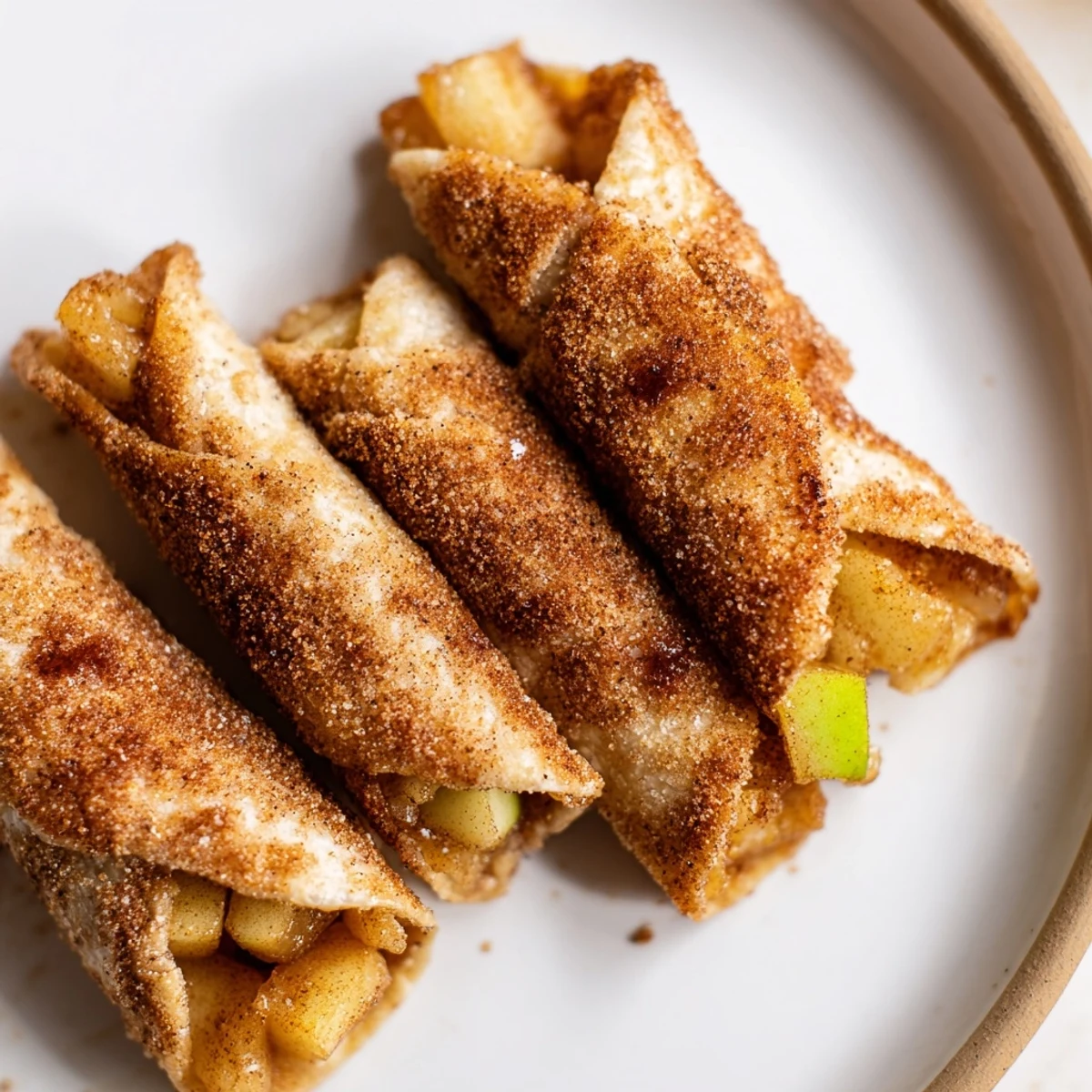 Golden-brown Apple Pie Roll-Ups fresh from the oven, ready to be enjoyed with a sweet cinnamon crust.