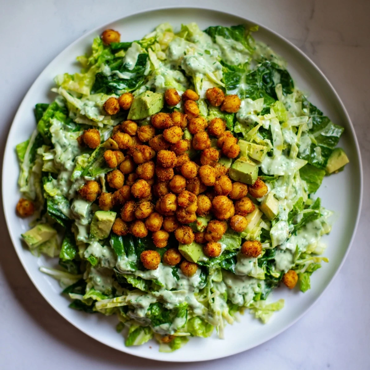 Enjoy a close-up of Green Goddess Salad, showing crunchy air-fried chickpeas atop a fresh, vibrant mix.