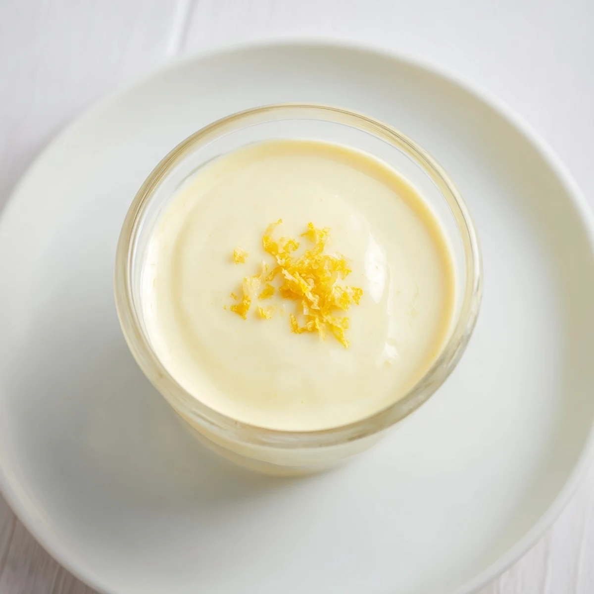 Creamy lemon posset in clear glasses, garnished, a perfect British dessert for a refreshing treat.