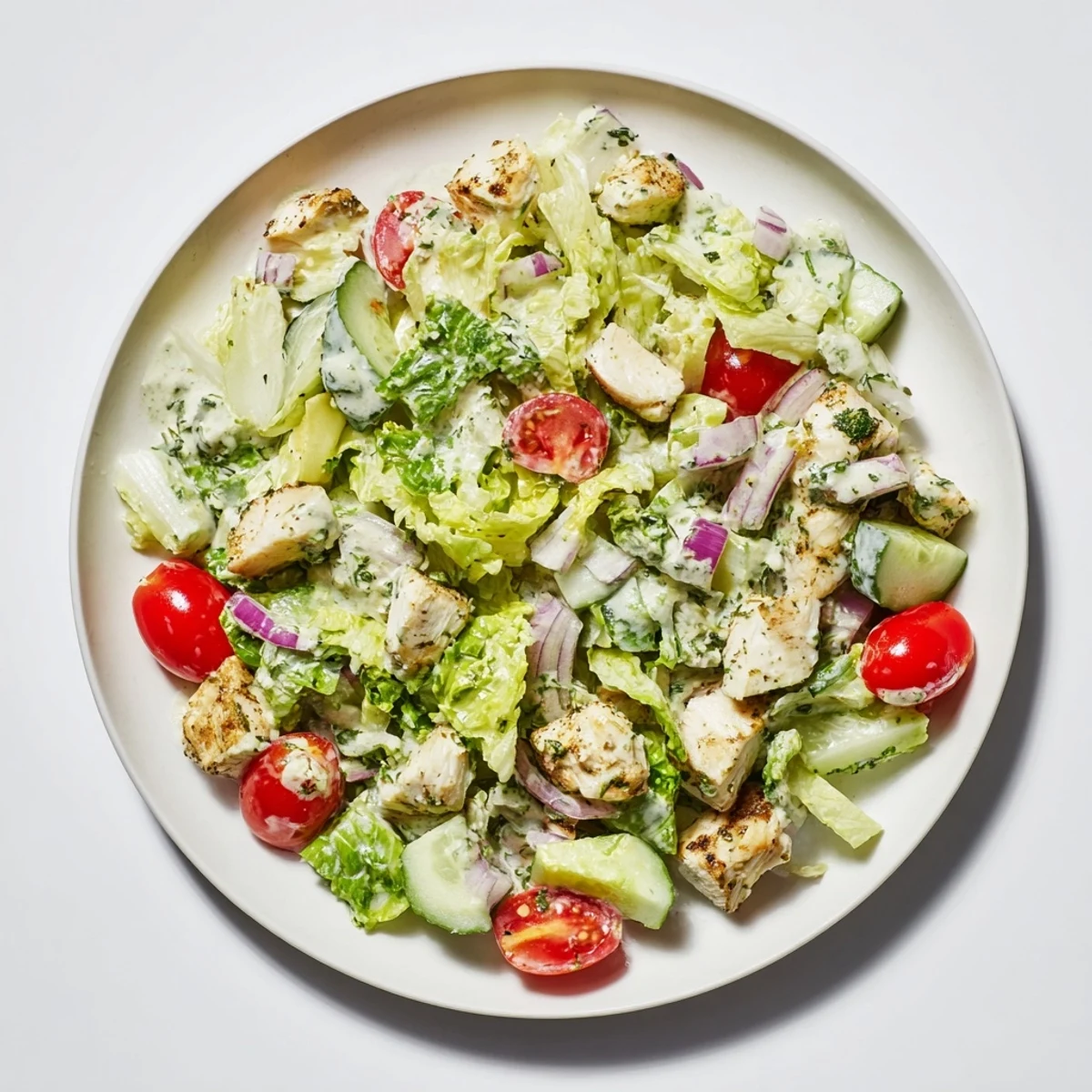 A vibrant bowl of avocado ranch chicken salad featuring juicy chicken, crisp veggies, and fresh herbs for an easy American dinner.