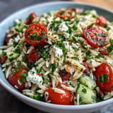 Refreshing orzo salad with feta, vibrant vegetables, and a zesty lemon dressing.