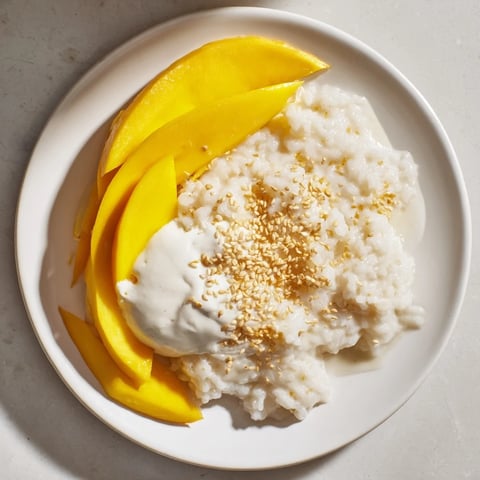 Sweet Thai Mango Sticky Rice: A visual of creamy, coconut-infused rice next to ripe mango slices, perfect dessert.
