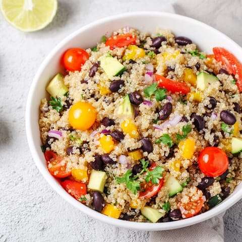 This vibrant quinoa and black bean salad features a zesty lime dressing, ready to enjoy.