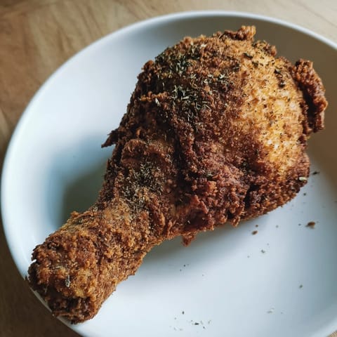 A close-up of perfectly fried KFC Crispy Chicken with a flavorful, seasoned crust, delicious!