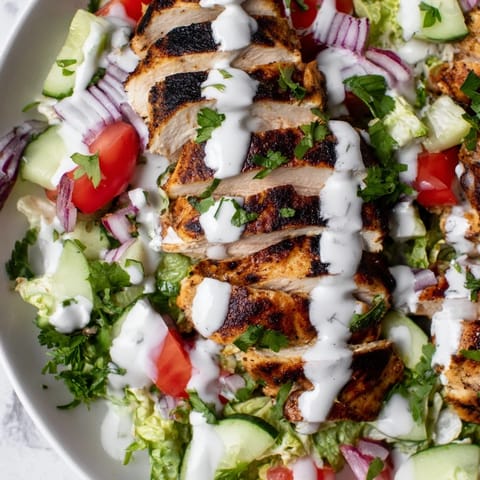 Vibrant bowl of Chicken Shawarma Salad featuring tender marinated chicken, crisp veggies, and a tangy yogurt drizzle for a refreshing meal.