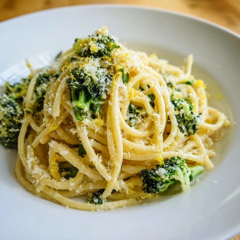 Savory One-Pot Lemon Broccoli Pasta served hot, garnished with fresh parsley and a wedge of lemon on a rustic wooden table.  