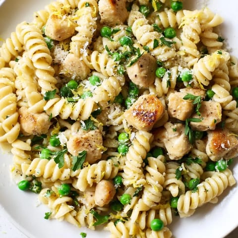 Savory Garlic Butter Chicken & Pea Pasta features golden chicken pieces mixed with sweet peas and al dente rotini in a rich sauce.