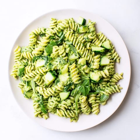 Green Goddess Pasta Salad served chilled in a white bowl, garnished with fresh basil and parsley.
