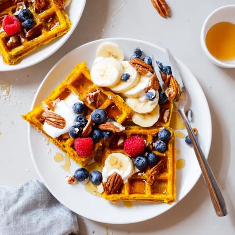 Vibrant yellow Anti-Inflammatory Adaptogenic Turmeric Waffles stacked high, infused with warm ginger and cardamom, ready for a nourishing breakfast. 