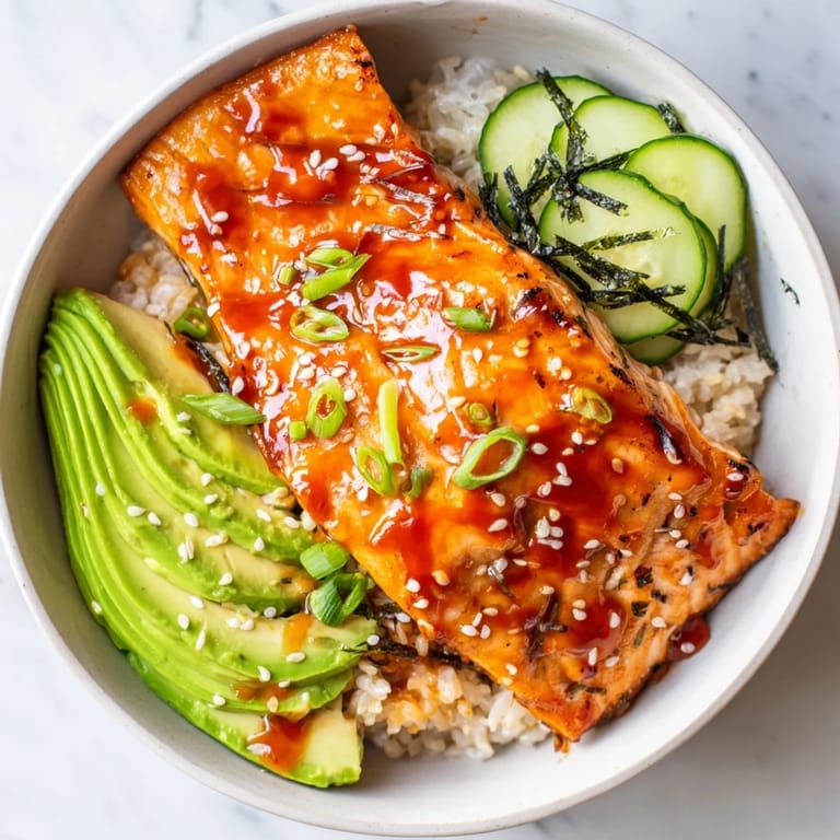 Close-up of a delicious Emily Mariko-Inspired Sticky Orange Gochujang Salmon Bowl; a complete, flavorful meal.