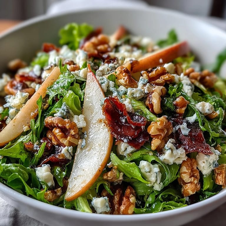 A freshly tossed Frisée Pear Blue Cheese Bowl showcases tender greens, crunchy walnuts, and a zesty white wine vinaigrette drizzled on top.
