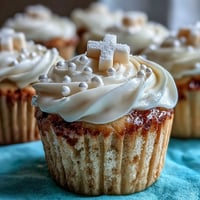 Soft vanilla Communion cupcakes adorned with delicate white fondant crosses.